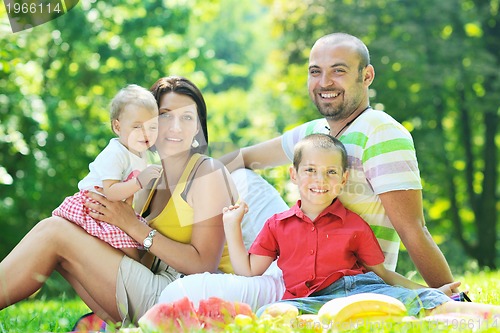 Image of happy young couple with their children have fun at park