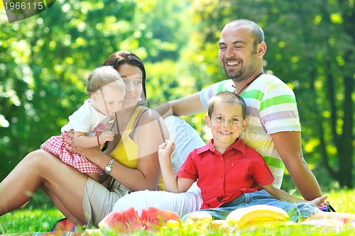 Image of happy young couple with their children have fun at park