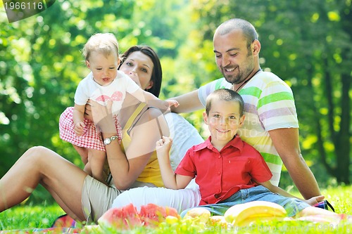 Image of happy young couple with their children have fun at park