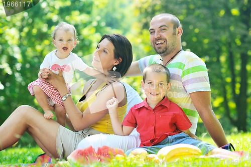 Image of happy young couple with their children have fun at park