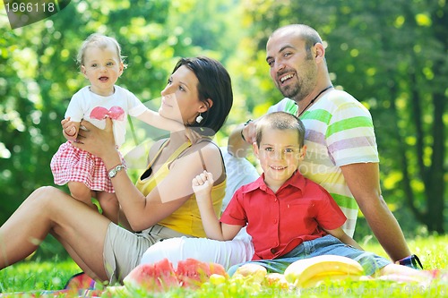 Image of happy young couple with their children have fun at park