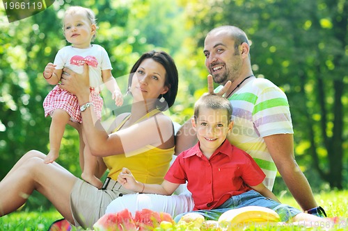 Image of happy young couple with their children have fun at park