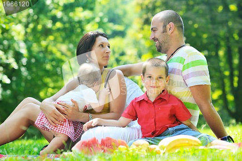 Image of happy young couple with their children have fun at park