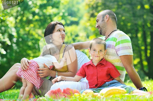 Image of happy young couple with their children have fun at park