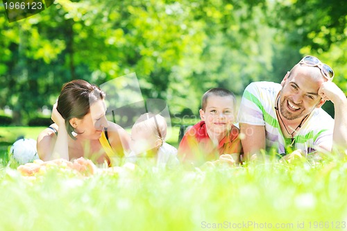 Image of happy young couple with their children have fun at park