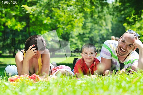 Image of happy young couple with their children have fun at park