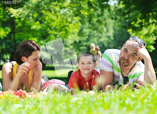 Image of happy young couple with their children have fun at park