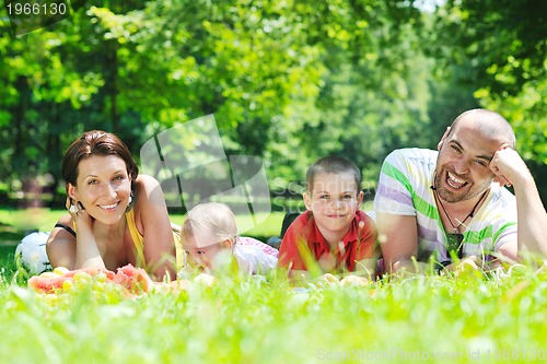 Image of happy young couple with their children have fun at park