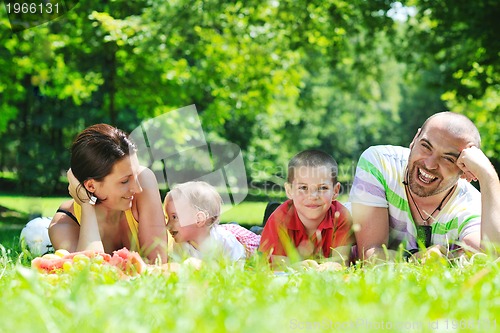 Image of happy young couple with their children have fun at park