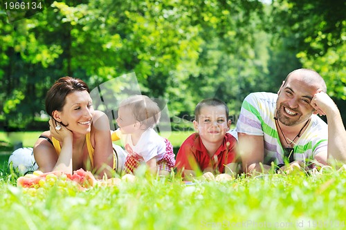 Image of happy young couple with their children have fun at park