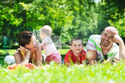 Image of happy young couple with their children have fun at park