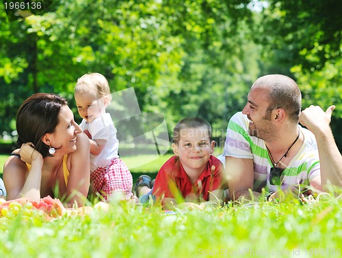 Image of happy young couple with their children have fun at park