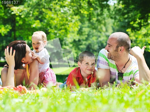 Image of happy young couple with their children have fun at park