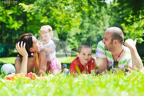 Image of happy young couple with their children have fun at park