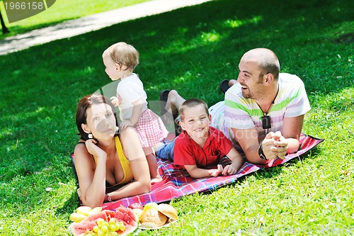 Image of happy young couple with their children have fun at park