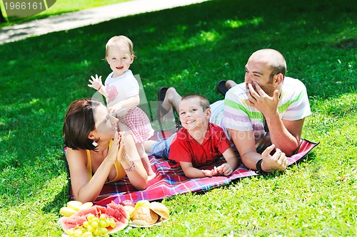 Image of happy young couple with their children have fun at park