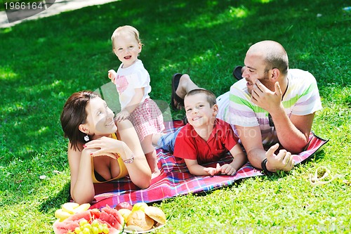 Image of happy young couple with their children have fun at park