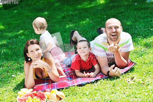 Image of happy young couple with their children have fun at park