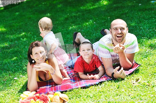 Image of happy young couple with their children have fun at park