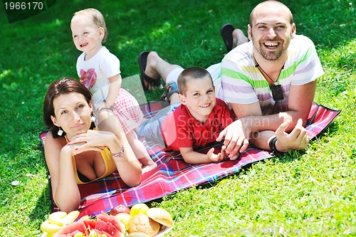 Image of happy young couple with their children have fun at park