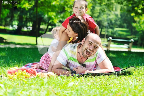 Image of happy young couple with their children have fun at park
