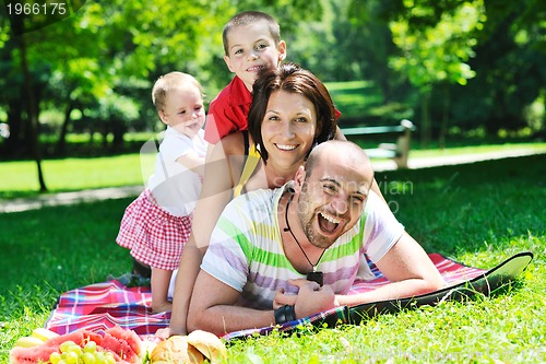 Image of happy young couple with their children have fun at park