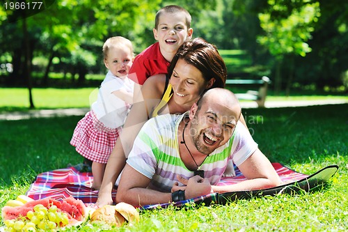 Image of happy young couple with their children have fun at park