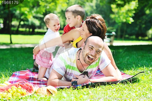 Image of happy young couple with their children have fun at park