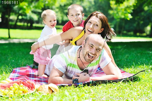 Image of happy young couple with their children have fun at park