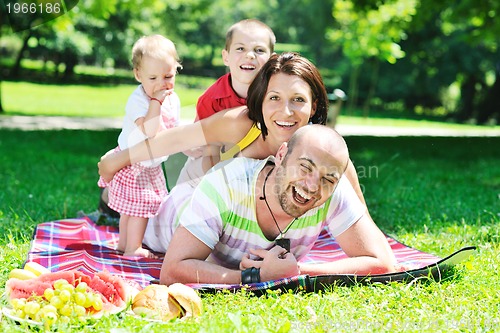 Image of happy young couple with their children have fun at park