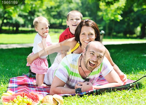 Image of happy young couple with their children have fun at park