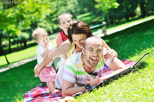 Image of happy young couple with their children have fun at park