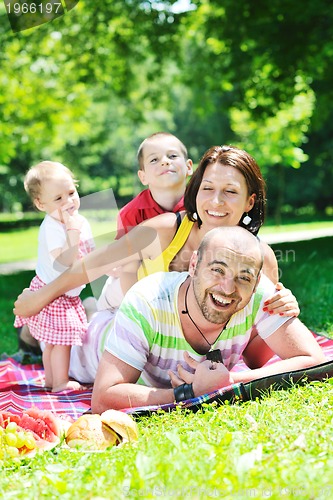 Image of happy young couple with their children have fun at park