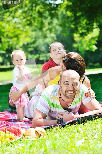 Image of happy young couple with their children have fun at park
