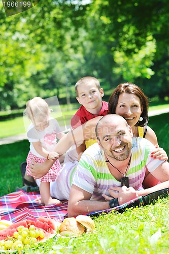 Image of happy young couple with their children have fun at park