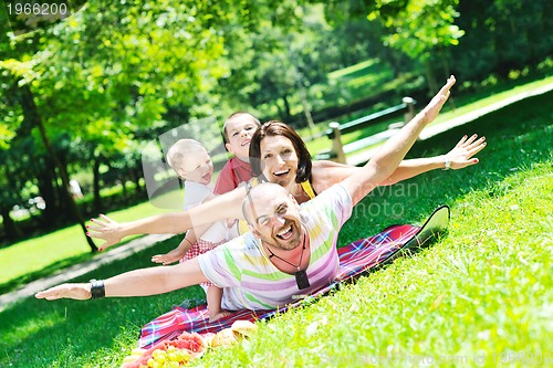 Image of happy young couple with their children have fun at park