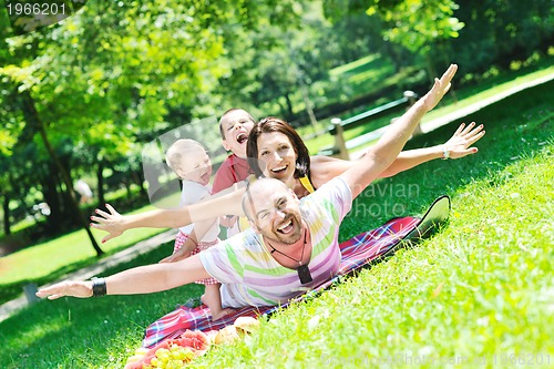 Image of happy young couple with their children have fun at park