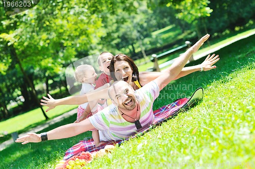 Image of happy young couple with their children have fun at park