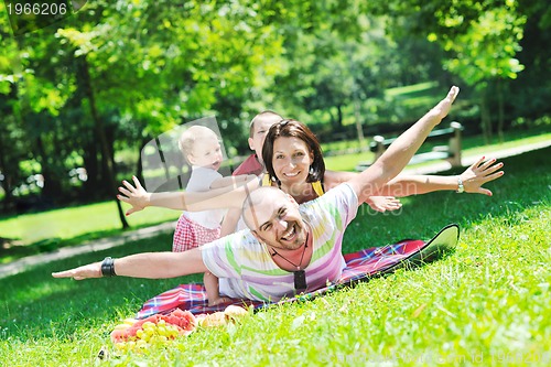 Image of happy young couple with their children have fun at park