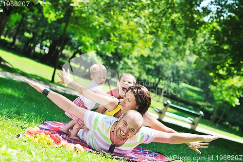Image of happy young couple with their children have fun at park