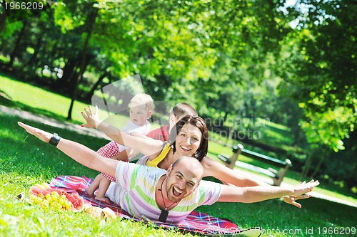 Image of happy young couple with their children have fun at park