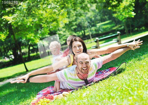 Image of happy young couple with their children have fun at park