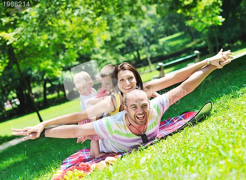 Image of happy young couple with their children have fun at park