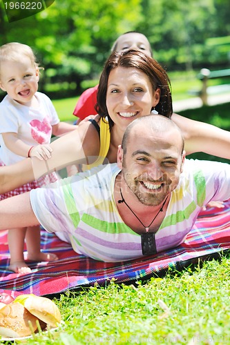 Image of happy young couple with their children have fun at park