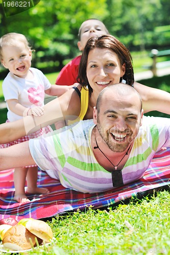 Image of happy young couple with their children have fun at park