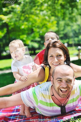 Image of happy young couple with their children have fun at park
