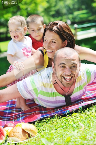 Image of happy young couple with their children have fun at park