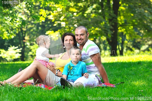 Image of happy young couple with their children have fun at park