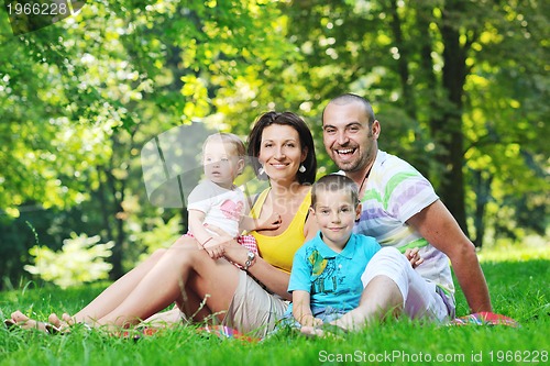 Image of happy young couple with their children have fun at park