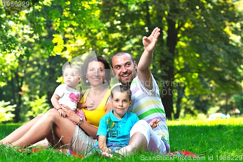 Image of happy young couple with their children have fun at park